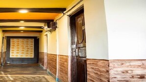 Um corredor estreito com painéis de madeira nas paredes e um tapete estampado.