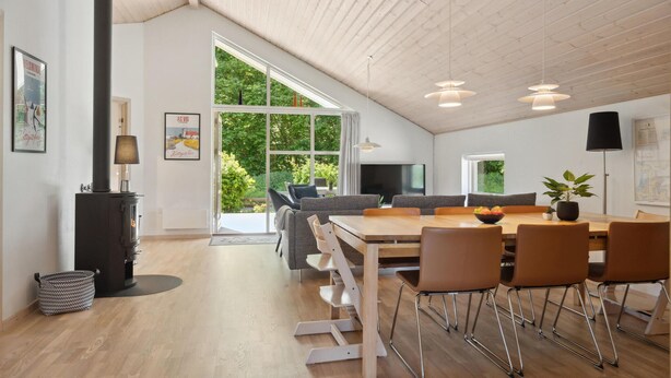 Une pièce spacieuse avec un plafond haut, une grande table à manger et des sièges confortables.