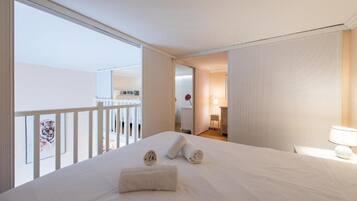 Una camera d'albergo con un letto grande, un balcone e vista sull'esterno.