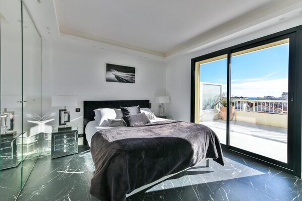 Une chambre moderne avec un grand lit, une douche en verre et un balcon avec vue.