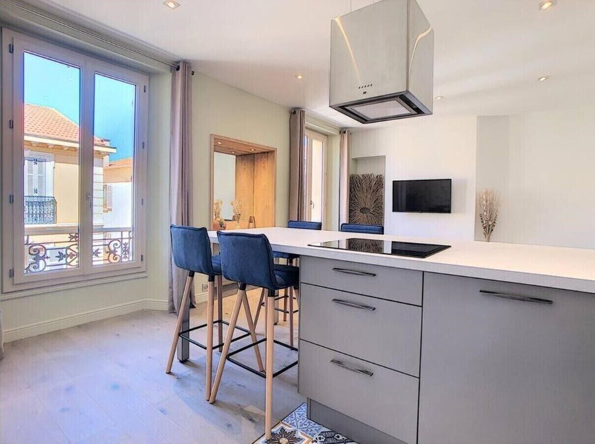 Una cucina moderna con un'isola grande, sgabelli da bar e un forno integrato.