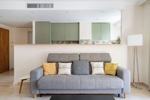 A modern living room with a grey sofa, a coffee table, and a floor lamp. - Le Corail spacieux avec beau et ample balcon (Cannes)