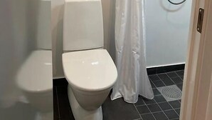 Un baño pequeño con inodoro, ducha y cortina.