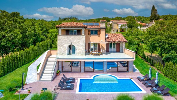 Une maison à deux étages avec une piscine, un espace salon extérieur et un jardin.