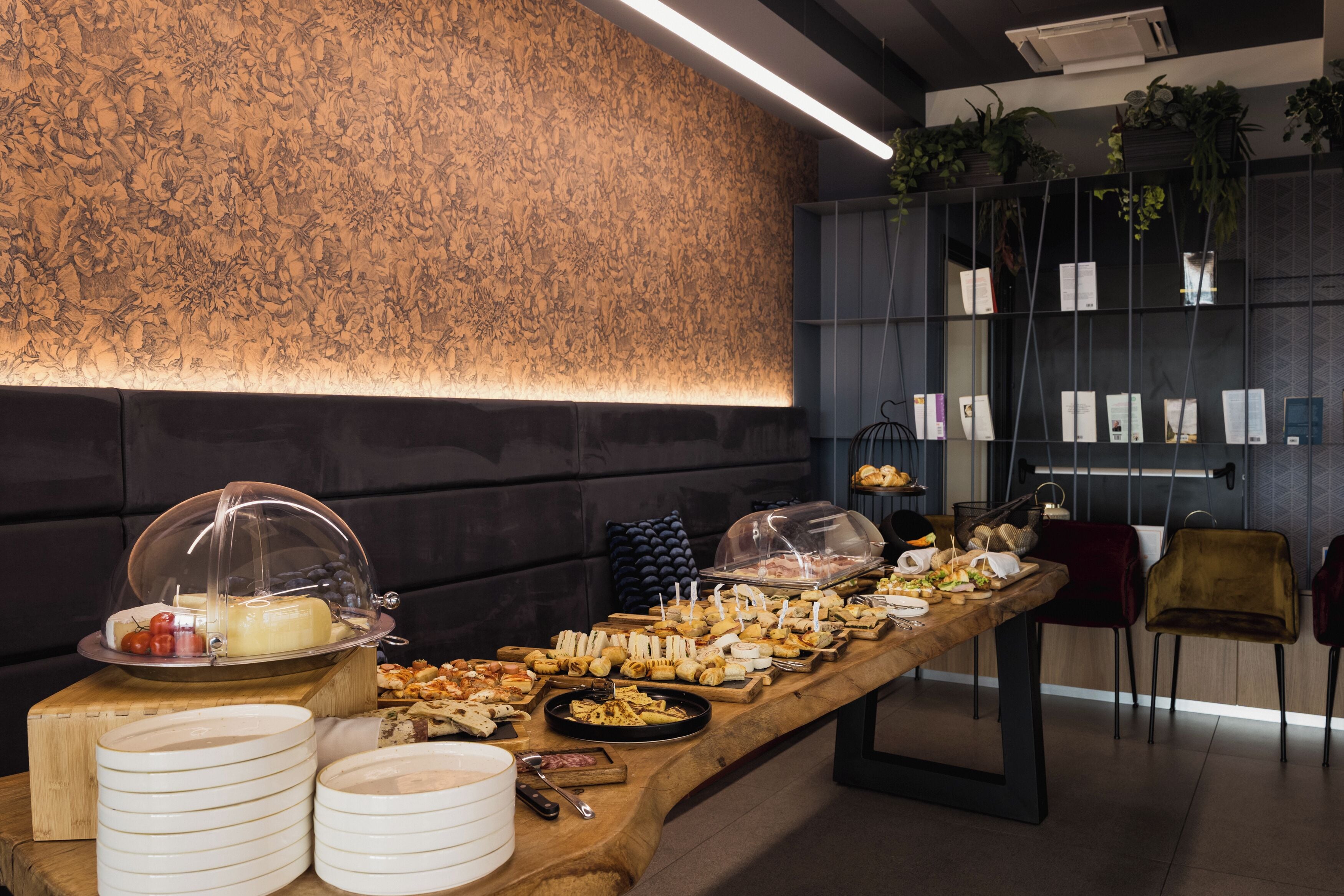 Ein reichhaltiges Buffet mit verschiedenen Speisen und eine Wand mit einer strukturierten Oberfläche.