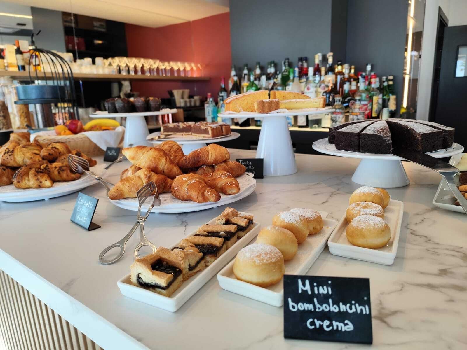 Una variedad de pasteles y postres exhibidos sobre una barra de mármol en un café.