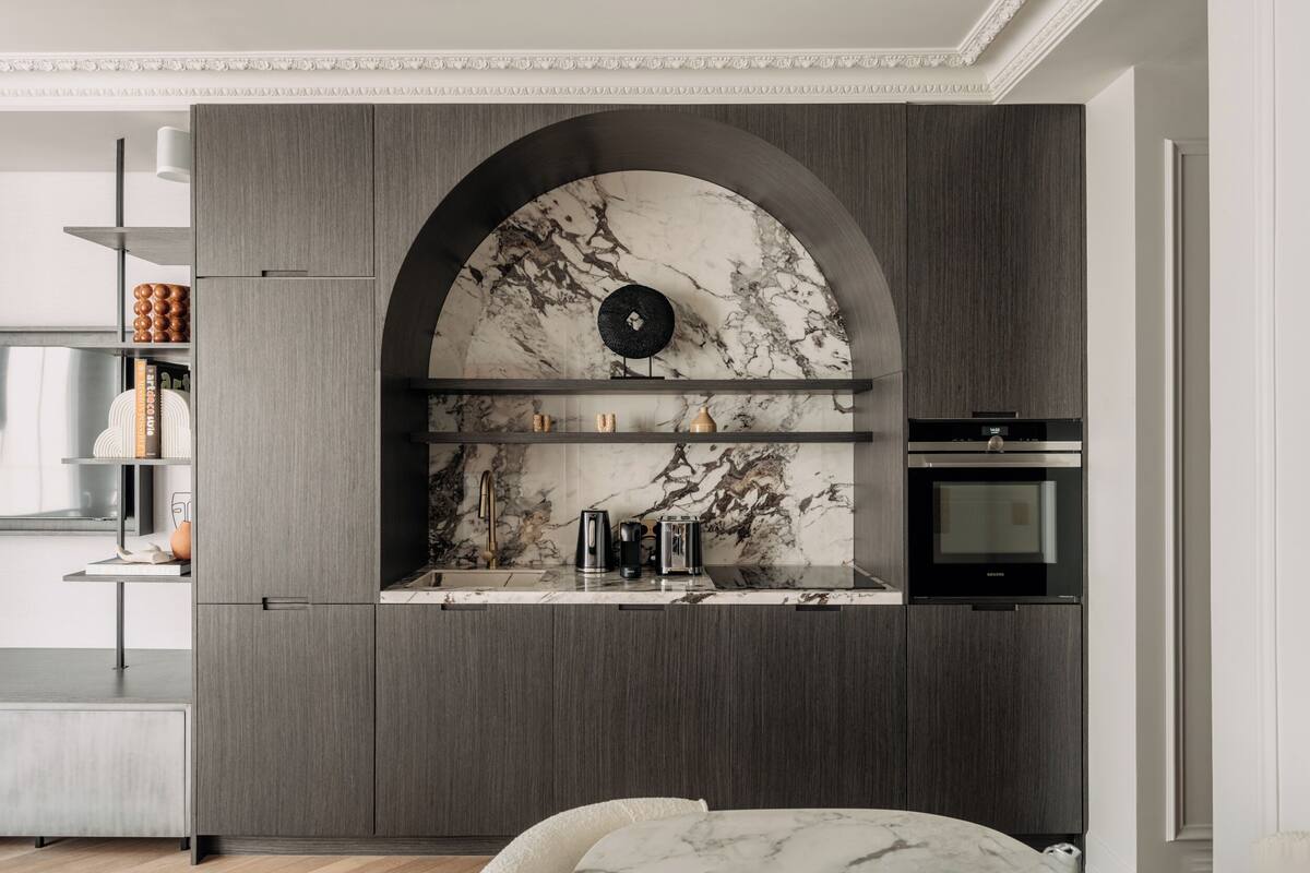 A modern kitchen with a marble backsplash, built-in appliances, and a minimalist design.