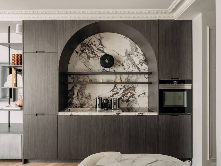 A modern kitchen with a marble backsplash, built-in appliances, and a minimalist design.