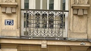 A double wooden door with intricate carvings, a balcony with wrought iron railings, and a stone facade. - HIGHSTAY - Luxury Serviced Apartments - Centre Pompidou Museum (Paris)