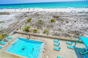 A pool area with a view of the beach and ocean.