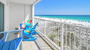 Un balcone con sedie blu e vista sulla spiaggia.
