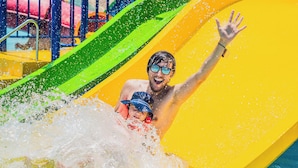 Uno scivolo acquatico con una persona e un bambino in fondo.