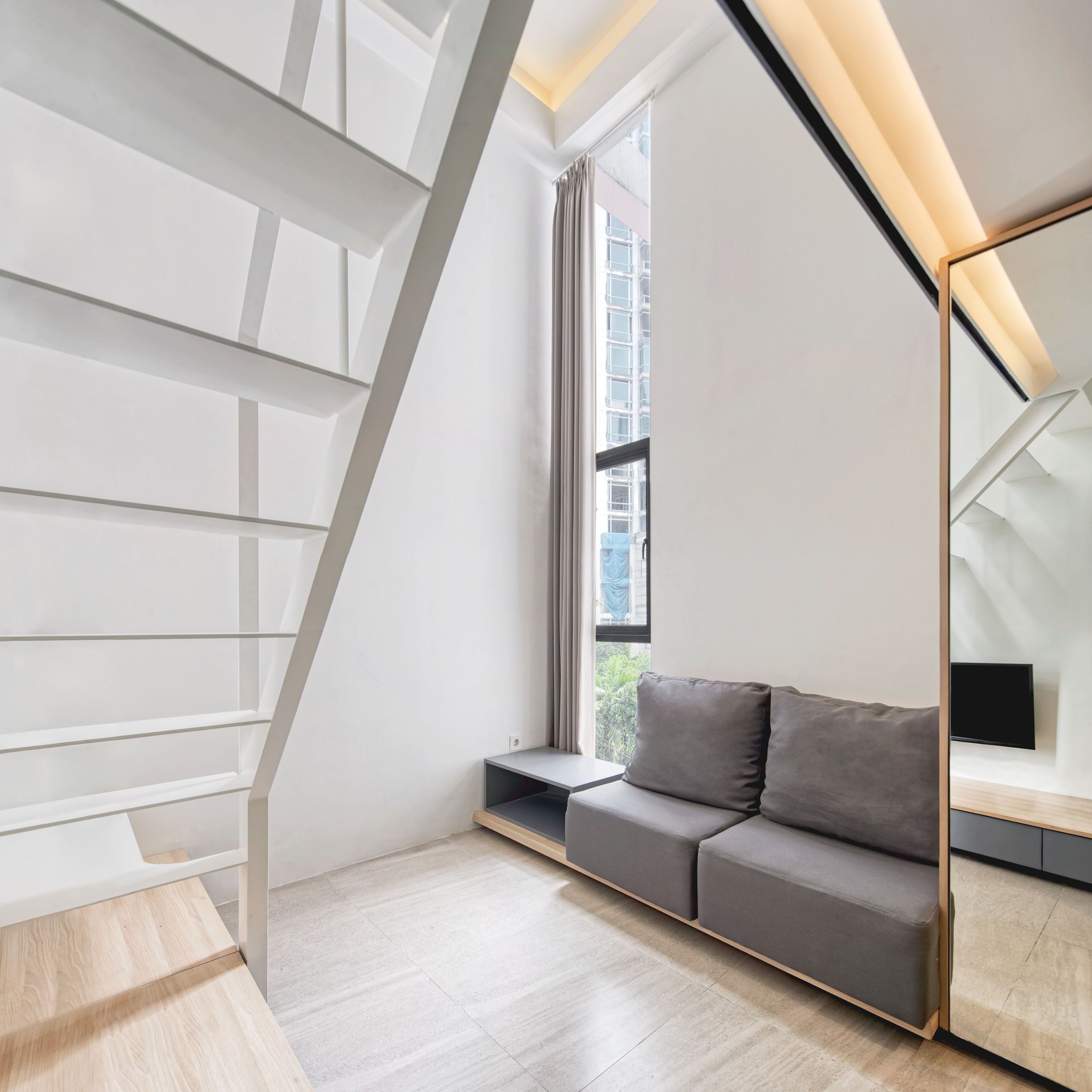 A modern interior with a built-in bench, a flat-screen TV, and a staircase with integrated lighting.