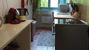 Una cucina compatta con una finestra, una macchina da caffè e un frigorifero.