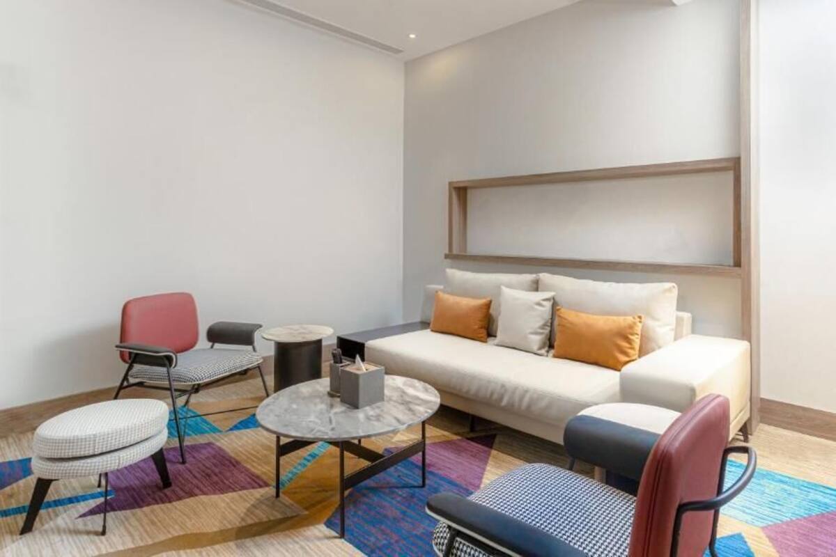 A modern living room with a sofa, two armchairs, a coffee table, and a floor lamp.