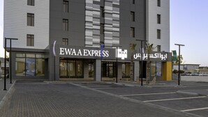 A modern hotel building with a sign reading "EWA EXPRESS HOTELS" and Arabic text.