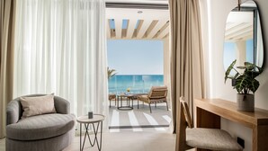 Habitació moderna amb un sofà corbat, un escriptori de fusta i vista a l'oceà.