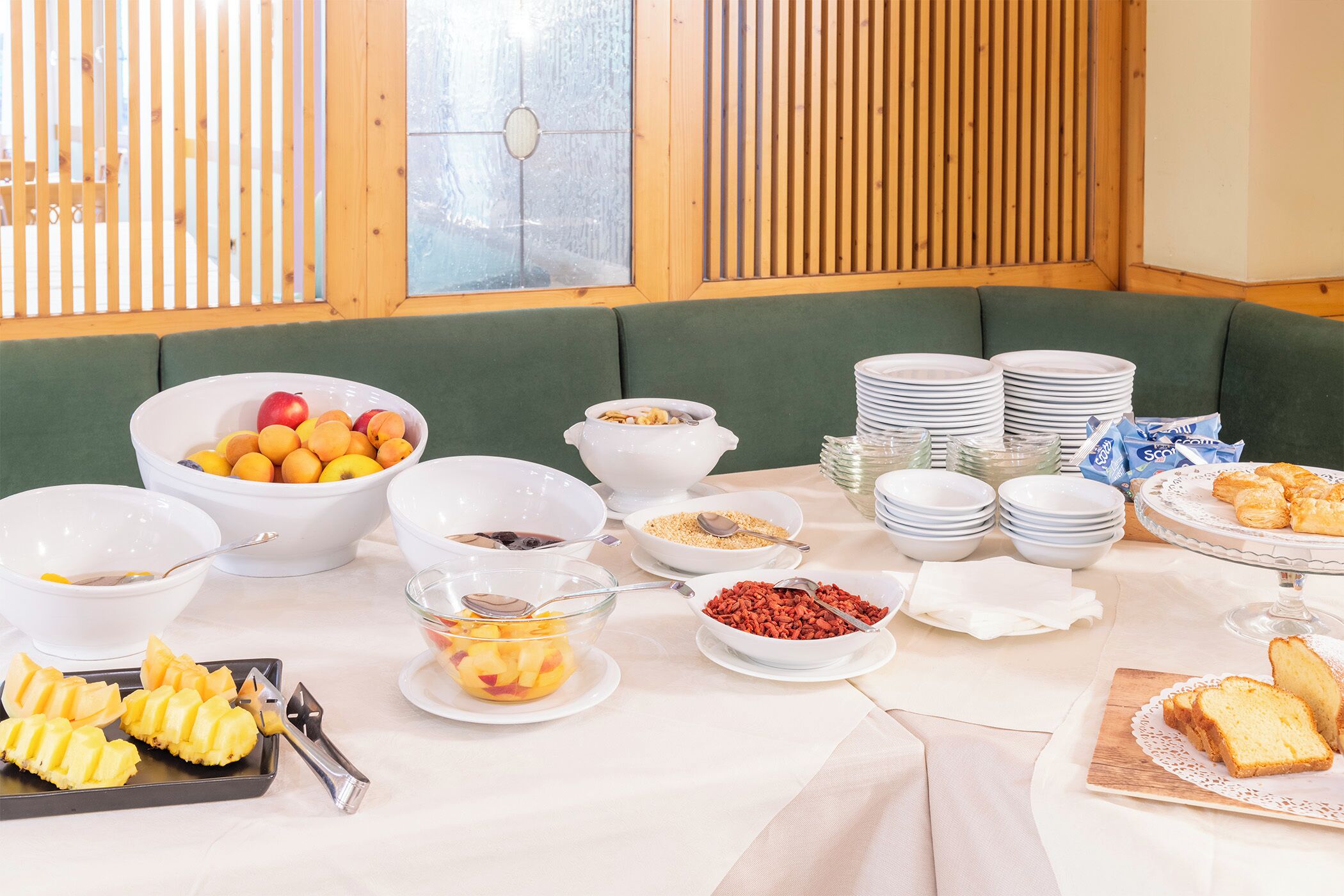 Ein Frühstücksbuffet mit verschiedenen Speisen und einer gepolsterten grünen Bank.
