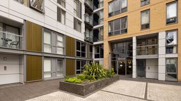 Un edificio moderno de varios pisos, con amplios ventanales y un patio central con plantas.