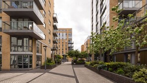 Una zona residencial moderna en la ciudad, con edificios de varios pisos, balcones y un sendero pavimentado.