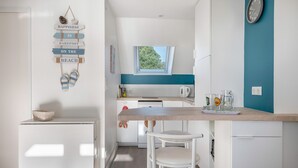 Eine moderne Küche mit einer Holzarbeitsplatte, weißen Schränken und einem Fenster über der Spüle.