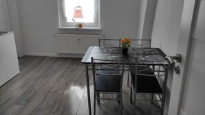 A small dining area with a table and chairs, a window with a view, and a radiator below. - Beautiful apartment on the roof floor for 5 people (Zeitz)