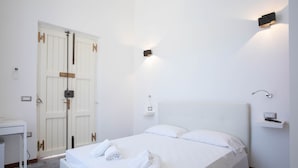 A hotel room with a bed, a desk, and a wardrobe. - Downtown poolfront room with private veranda (Oristano)