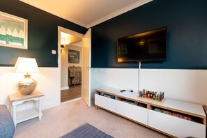 Relax in this stylish living room with a flat-screen TV, side table, and comfortable bench.