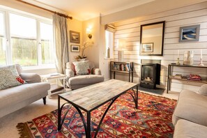 Relax in this inviting living room with a sofa, coffee table, and fireplace.