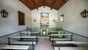 En kapel med bænke, et midteraltre og religiøse malerier på væggene.