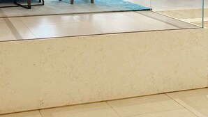 A set of beige marble stairs leading to a higher level, with a glass railing on the right. - HomesGetaway-1Bedroom in JBR The Address (Dubai)