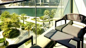 A balcony with a view of a landscaped area, a bridge, and a body of water. - HomesGetaway-1Bedroom in JBR The Address (Dubai)