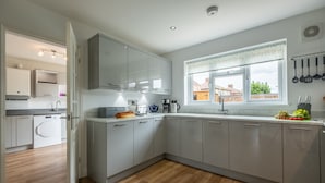 Eine moderne Küche mit grauen Schränken, einem eingebauten Backofen und einem Fenster mit Blick nach draußen.
