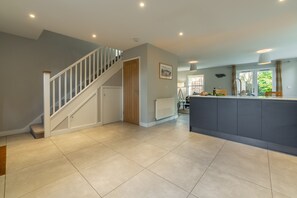 Modern kitchen with central island, oven, and stainless steel sink, offering a convenient cooking space.