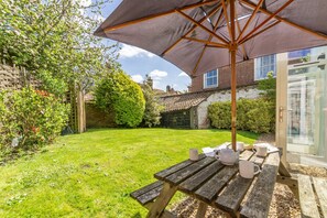 Enjoy a serene meal or tea for two in this peaceful outdoor setting, complete with a picnic table and umbrella.