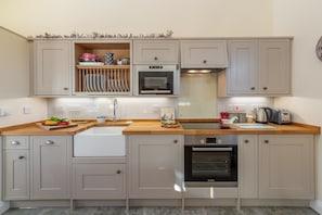 Enjoy cooking and entertaining in this well-equipped kitchen with a double sink, oven, and ample storage.