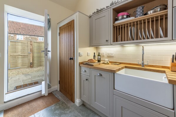 Enjoy a bright and airy kitchen with a large window, sink, and access to an outdoor space.