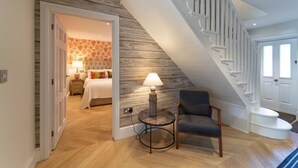 A staircase leading to a bedroom with a bed, a chair, and a lamp. - Drifters, Thornham, Norfolk (Thornham)