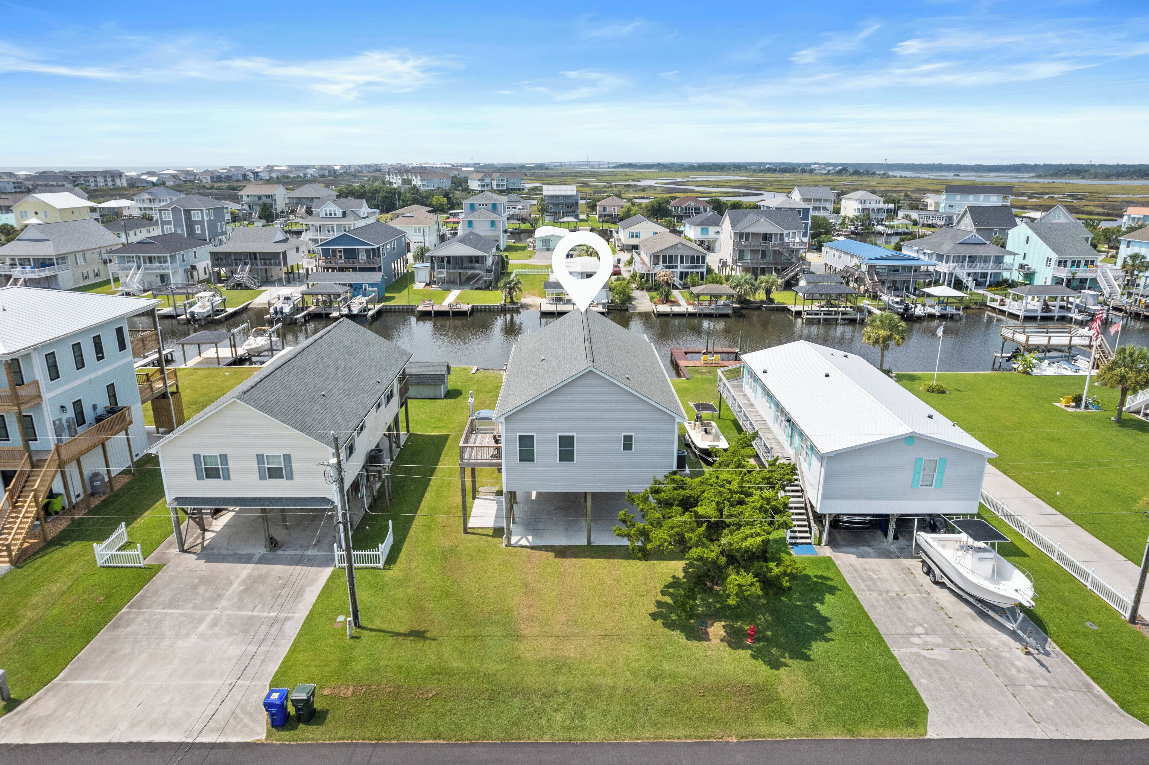 A residential area with houses, a marina, and a large body of water.