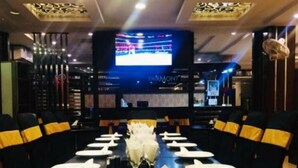 A conference room with a long table set for a meeting, a television screen in the background, and a sign that reads "ARMONT". - Fair Mont (Multan)