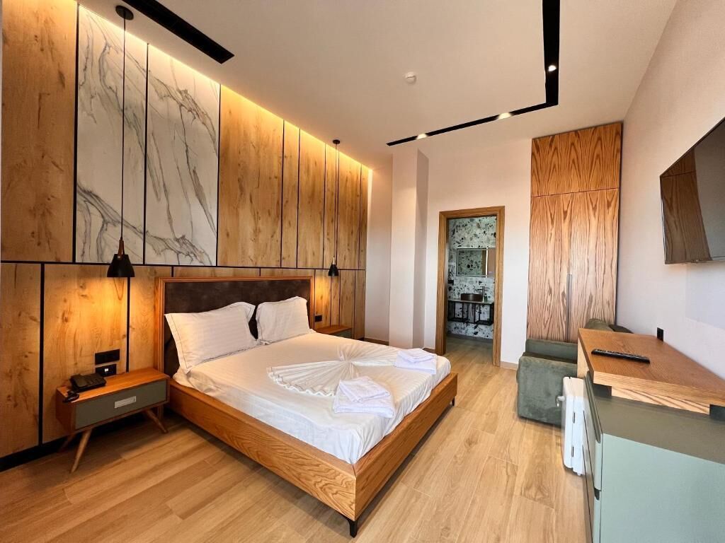 Un dormitorio moderno con una cama de madera, mesitas de noche y un armario empotrado.
