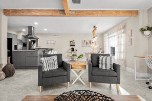 Relax in a cozy seating area with two armchairs and a dining table for four.