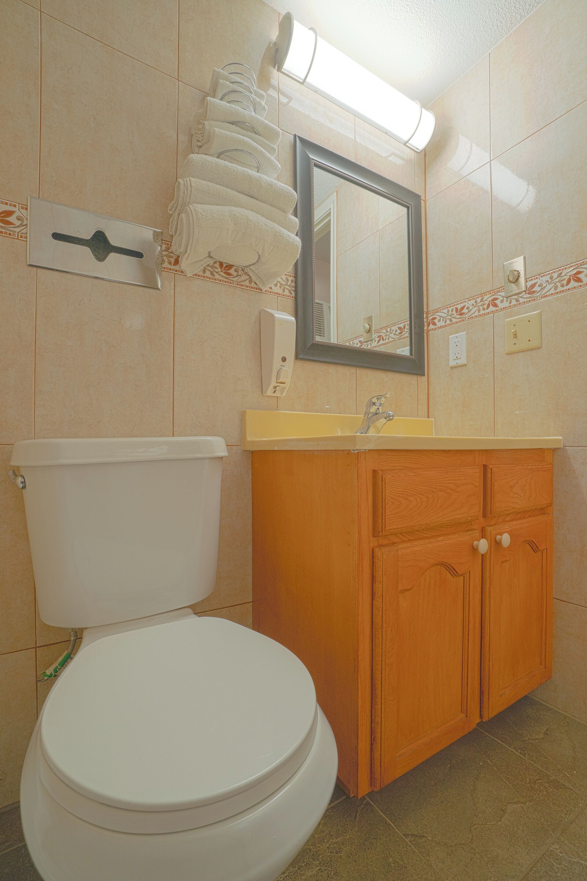 Ein Badezimmer mit Toilette, Waschbecken und Holzschrank.