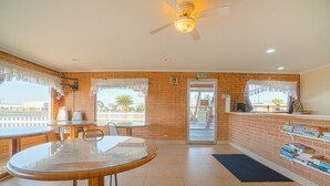 A spacious kitchen with a dining area, a ceiling fan, and a view of the outside.