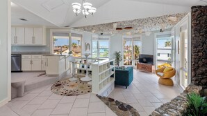 Un área de estar amplia con cocina, comedor y vistas al exterior.