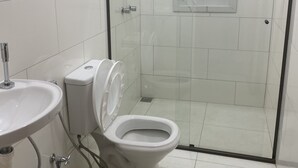 A modern bathroom with a glass-enclosed shower, a white toilet, and a sink. - Pousada Cachoeira do Sol (Taquaraçu de Minas)