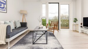 Uma sala de estar moderna com um sofá, mesa de centro e televisão.
