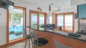 Una cocina moderna con barra, ventanas amplias y vistas al exterior.