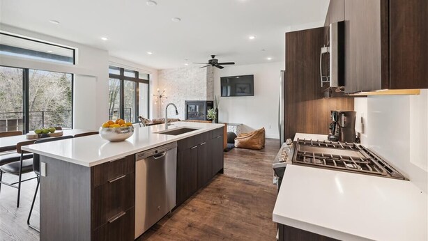 A modern kitchen with a central island, dark cabinetry, a built-in oven, and a large window providing natural light. - River West 924 - Silverthorne Condo with River Views. (Silverthorne)