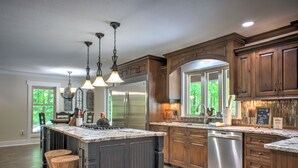 A spacious kitchen with dark wood cabinets, stainless steel appliances, and a large island.